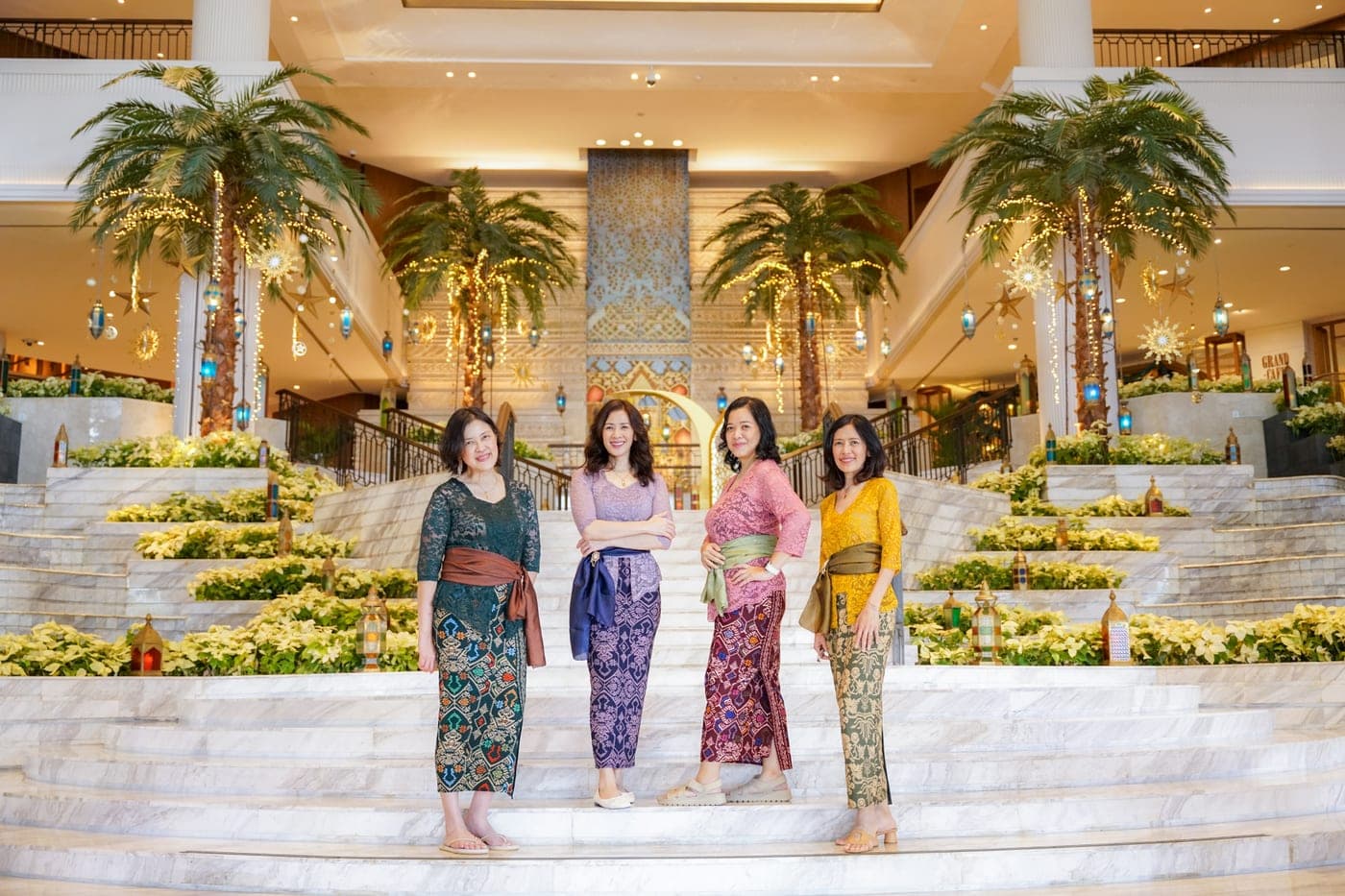 Four women posing together on stairs with floral decorations